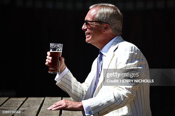 Reform UK leader Nigel Farage sits and poses with a pint in the garden of The Ship pub after casting his vote in the Clacton by-election earlier in...
