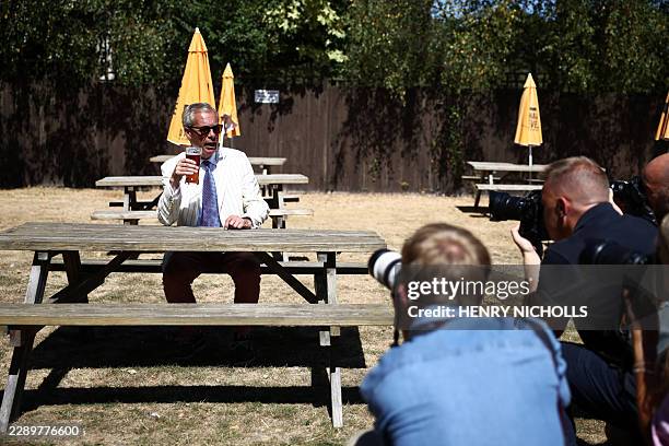 Reform UK leader Nigel Farage sits and poses with a pint in the garden of The Ship pub after casting his vote in the Clacton by-election earlier in...