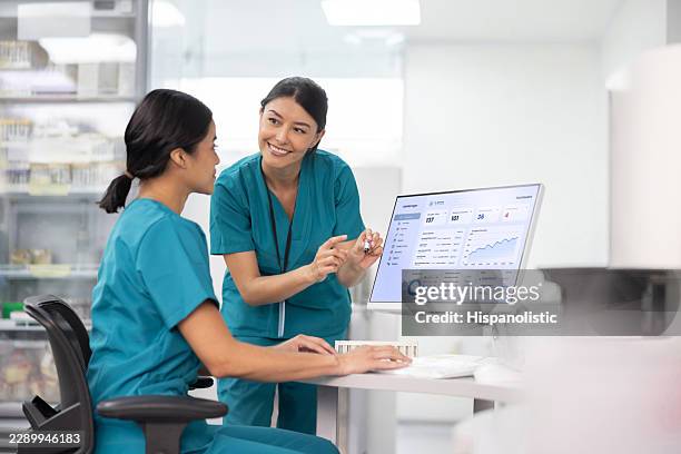lab technician training a new hire while processing blood samples - computer forensics stock pictures, royalty-free photos & images
