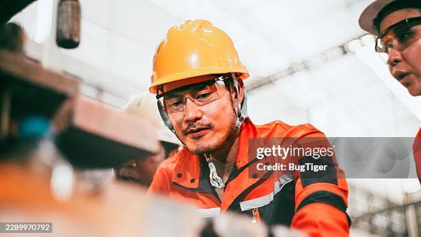 engineering team conducting routine maintenance in a modern factory. - iron foundry stock pictures, royalty-free photos & images