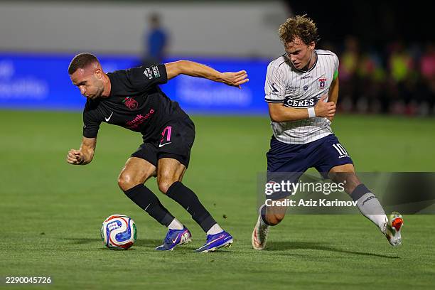 Veljko Simic of Sabah is challenged by Kristian Arnstad of Aarhus during the UEFA Champions League Third Qualifying Round 2nd leg between Sabah and...
