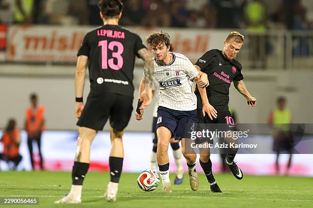 Aleksey Isayev of Sabah is challenged by Magnus Knudsen of Aarhus during the UEFA Champions League Third Qualifying Round 2nd leg between Sabah and...