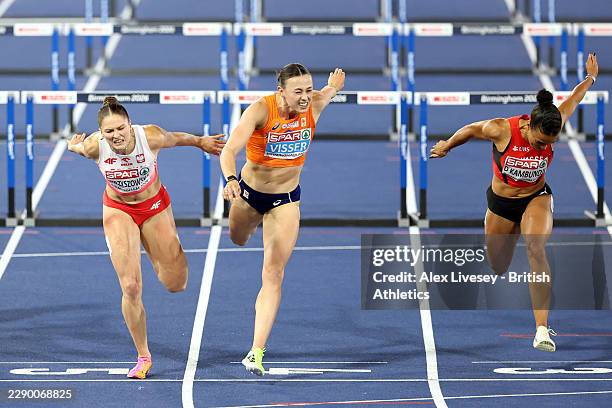 Pia Skrzyszowska of Team Poland and Nadine Visser of Team Netherlands cross the finish line in the Women's 100m Hurdles Final during day two of the...