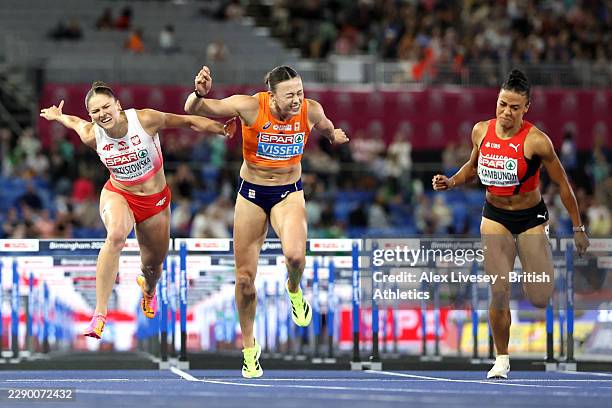 Pia Skrzyszowska of Team Poland and Nadine Visser of Team Netherlands stretch to cross the finish line in the Women's 100m Hurdles Final during day...