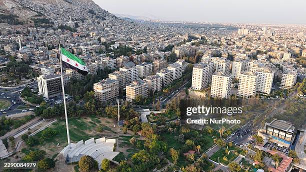 Drone view shows Umayyad Square in Damascus, Syria, on August 14 with a large Syrian flag flying over the plaza and surrounding city landscape.