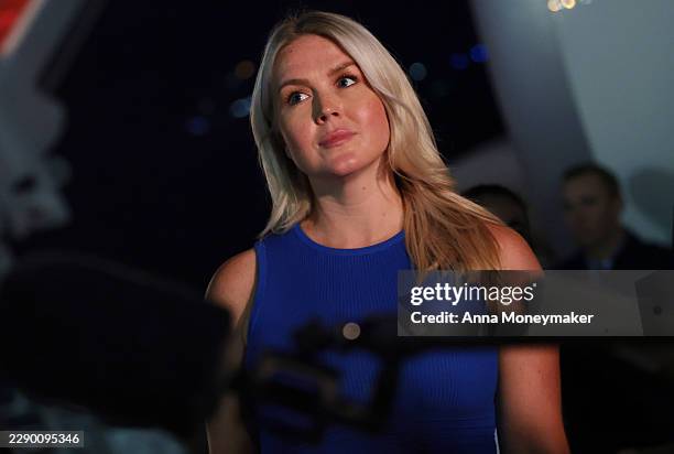 White House Press Secretary Karoline Leavitt looks on as U.S. President Donald Trump speaks to reporters after stepping off Air Force One on August...