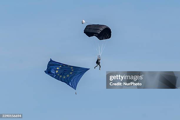 Paratrooper descends with a European Union flag trailing behind during the Polish Armed Forces Day military parade on the Wislostrada in Warsaw,...