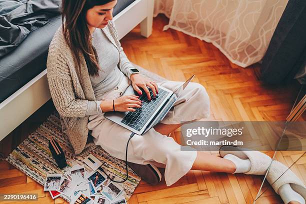 young woman printing and organizing instant travel photos at home - usb cable stock pictures, royalty-free photos & images