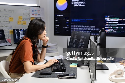 Software development team working at office desks with multiple code screens, monitoring system output and reviewing programming tasks to support debugging and reliable workflow. Software development team working at office desks with multiple code screens, monitoring system output and reviewing programming tasks to support debugging and reliable workflow.