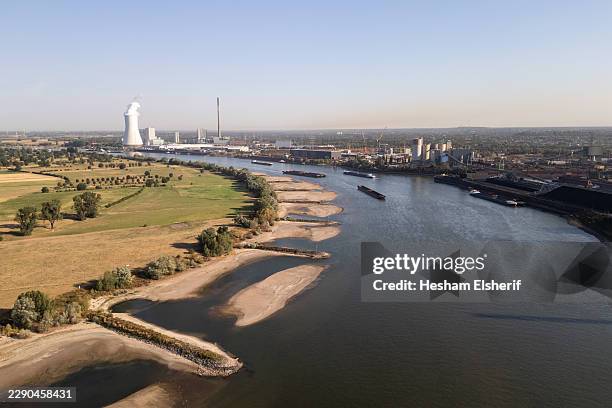 Cargo ship passes by an exposed sandbank on the Rhine River on August 14, 2026 in Duisburg, Germany. Water levels of the Rhine have reached historic...