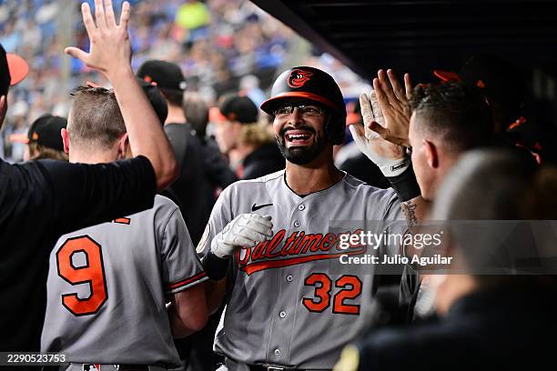 Christian Encarnacion-Strand of the Baltimore Orioles celebrates with teammates in the dugout after hitting a sacrifice fly to score Tyler O'Neill in...