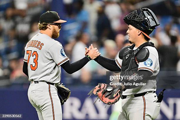 Cam Sanders of the Baltimore Orioles celebrates with Yohel Pozo after defeating the Tampa Bay Rays 6-5 at Tropicana Field on August 14, 2026 in St...