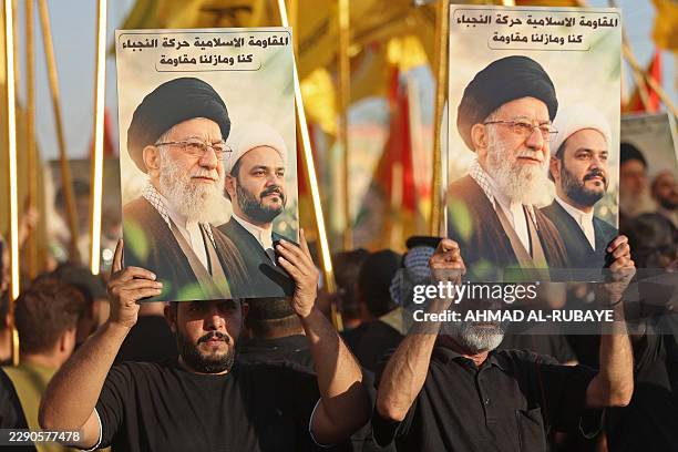 Demonstrators carry placards with pictures of Iran's late supreme leader Ali Khamenei and Akram al-Kaabi, Secretary-General of the Kataib al-Nujaa,...