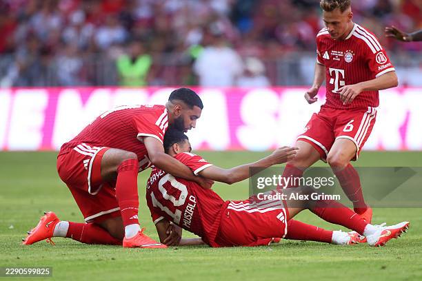 Ismael Saibari of Bayern Munich helps teammate Jamal Musiala who appears injured after going to ground during the Telekom Cup match between FC Bayern...