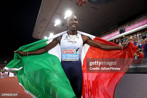Gold medalist Andy Diaz Hernandez of Team Italy poses for a photo with his national flag after victory in Men's Triple Jump Final during day six of...