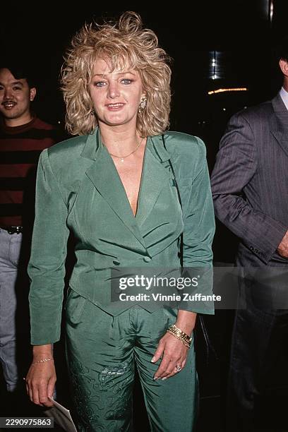 British singer and songwriter Bonnie Tyler, wearing a double-breasted green trouser suit, attends an event, United States, circa 1990.
