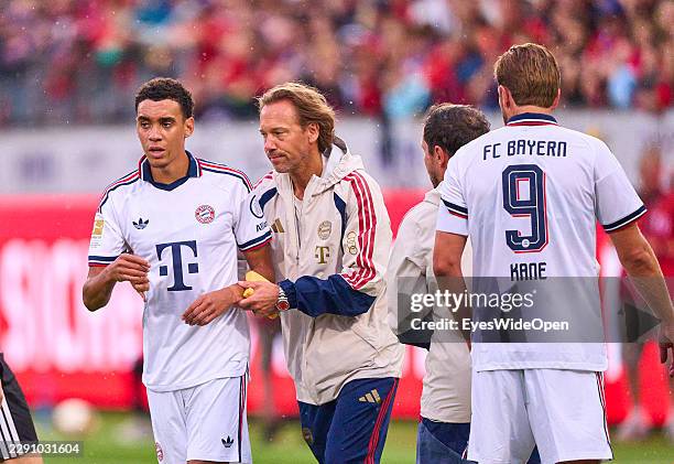 Jamal Musiala of FC Bayern München falls over during the match and requires treatment by FCB team doctor Prof. Dr. Peter Ueblacker during the...