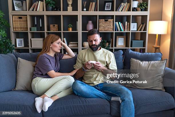 couple disappointed by negative home pregnancy test result - infertility stock pictures, royalty-free photos & images