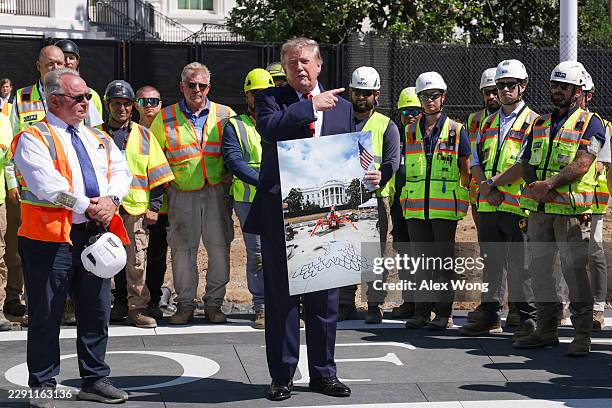 President Donald Trump speaks to the media alongside construction workers building a new helipad on the South Lawn of the White House continues on...