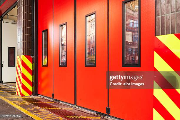 red fire station folding doors with reflective windows - folding door stock pictures, royalty-free photos & images