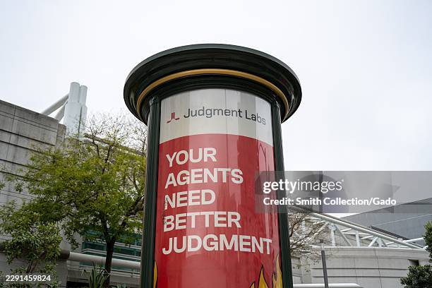 Judgment Labs advertisement reading "YOUR AGENTS NEED BETTER JUDGMENT" on a cylindrical street kiosk near Moscone Center, San Francisco, California,...