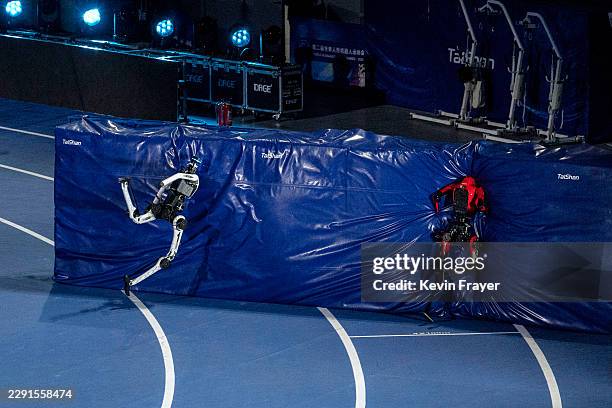 Humanoid robots crash into the crash pad at the end of a sprint in the 100 meter at the opening of the 2nd World Robot Games at National Speed...