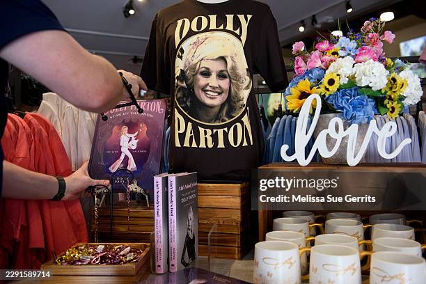 An emoloyee sets out books for display at the Dollywood gift store on August 26, 2026 in Pigeon Forge, Tennessee. Fans of Dolly Parton have gathered...