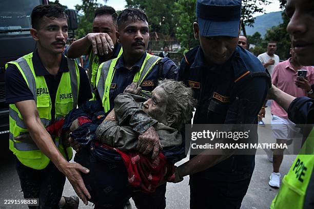 Rescuers carry in their arms a flood survivor, following flash floods and a landslide disaster in Devghat, in the Nepal's Nuwakot district on August...