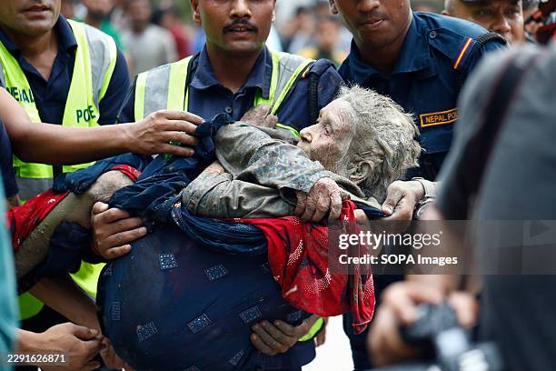 An elderly woman is rescued from buildings and infrastructure that were damaged along the swollen Trishuli River following a massive flash flood...