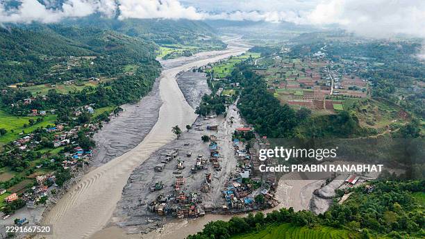 An aerial view shows houses lying deluged in sludge after flash floods at Devighat, Bidur Municipality, along the confluence of the Trishuli and Tadi...