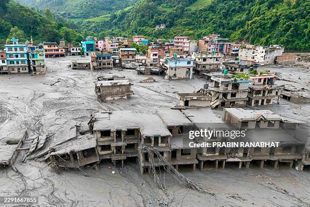 An aerial view shows houses lying deluged in sludge after flash floods at Devighat, Bidur Municipality in Nepal's Nuwakot district on August 27,...