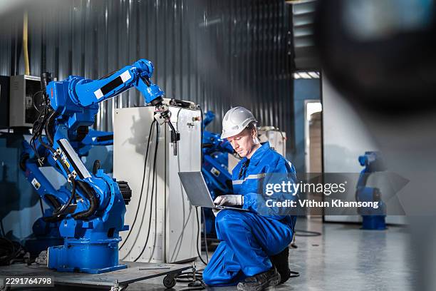 engineer programming robotic arm in modern factory for advanced manufacturing - mechatronics stock pictures, royalty-free photos & images