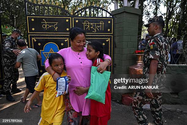 Woman embraces her daughters following their rescue from a flash flood site at Trishuli camp in Nepal's Nuwakot district on August 28, 2026....