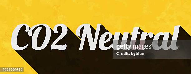 co2 neutral - text with long shadow on textured yellow background - carbon capture stock illustrations