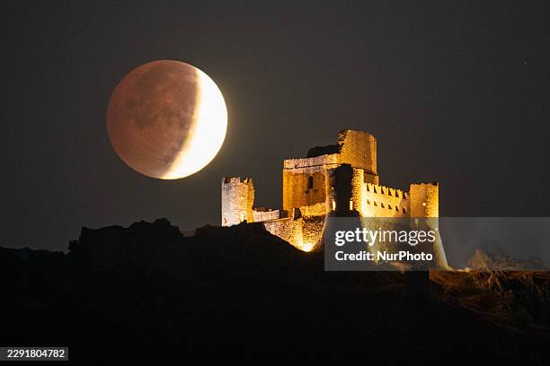 Partial lunar eclipse setting over Rocca Calascio fortress is seen from Calascio, Italy, on August 28th, 2026. A partial lunar eclipse occurs when...