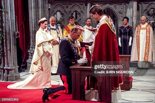 Picture taken on June 23, 1991 in Nidaros Cathedral, in Oslo, Norway, shows Norway's King Harald V being signed in by Bishop Finn Wagle, together...