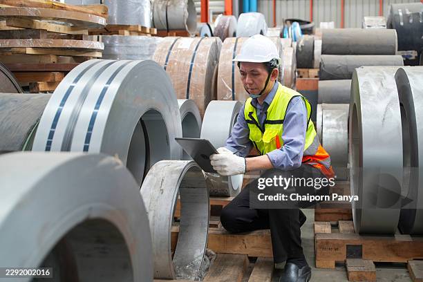 engineer checking steel coil inventory in factory warehouse - metallurgy stock pictures, royalty-free photos & images