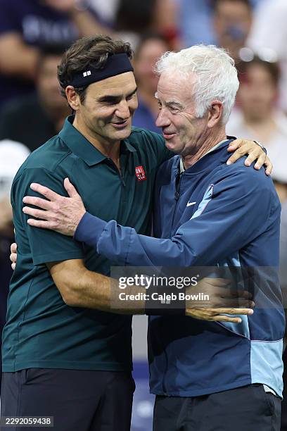 Roger Federer of Switzerland and John McEnroe of the United States embrace prior to during the exhibition doubles match against Andy Roddick of the...