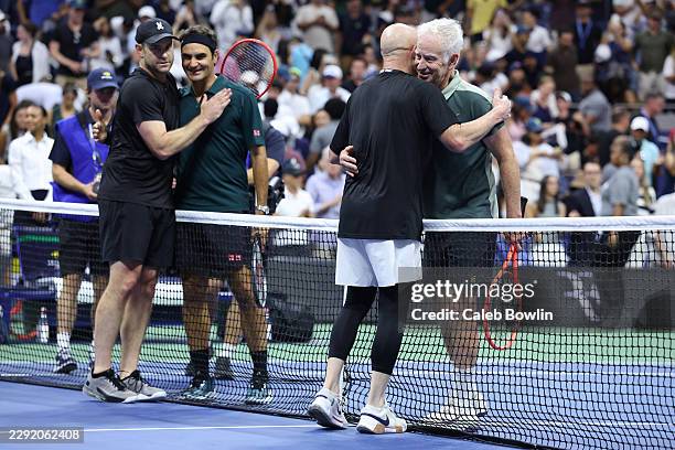 Roger Federer of Switzerland and John McEnroe of the United States embrace Andy Roddick of the United States and Andre Agassi of the United States...