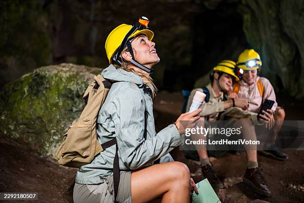 young adults exploring cave system using headlamps - cave torch stock pictures, royalty-free photos & images