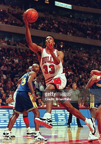 Forward Scottie Pippen of the Chicago Bulls goes up for the layup as guard Latrell Sprewell Golden State Warriors watches during their game at the...