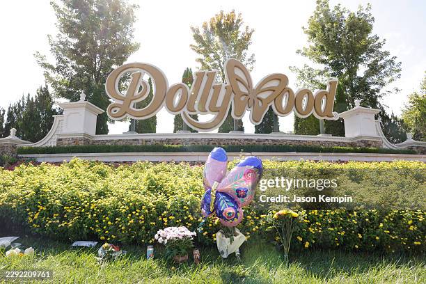 Flowers, balloons and candles are seen placed at the entrance of Dollywood on August 26, 2026 in Pigeon Forge, Tennessee. Parton passed away on...