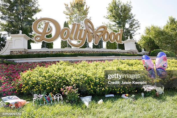 Flowers, balloons and candles are seen placed at the entrance of Dollywood on August 26, 2026 in Pigeon Forge, Tennessee. Parton passed away on...