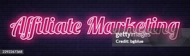 affiliate marketing - glowing neon text on brick wall background - referral program neon stock illustrations