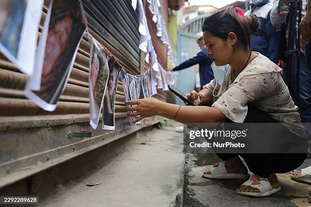 Families and relatives of missing persons from the Tibet-Nepal floods view images of bodies displayed on the walls of the Tribhuvan University...