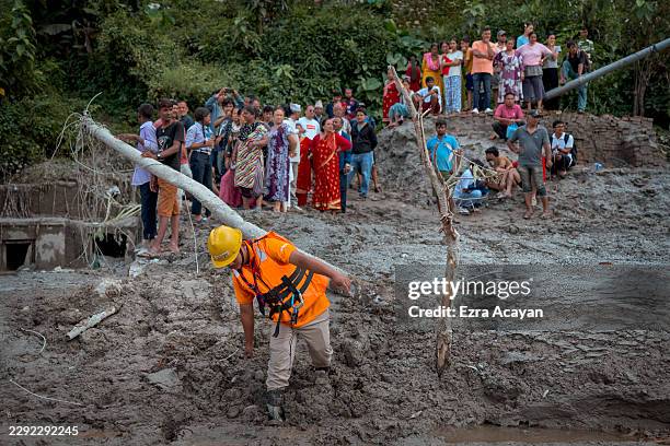 Residents survey the damage following flash floods on August 27, 2026 in Trishuli, Nepal. A sudden flood swept through the Bhote Koshi River basin in...