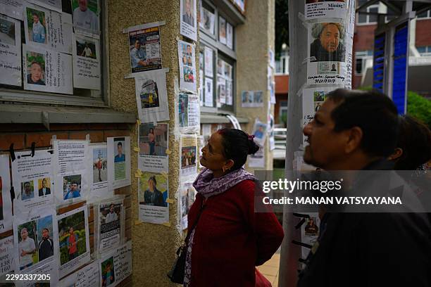 Relatives look at photographs of missing persons in the aftermath of flash floods, at the Tribhuvan University Teaching hospital in Kathmandu on...
