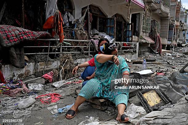 People salvage belongings from their home following flash floods at Devighat in Nepal's Nuwakot district on August 31, 2026. Nepal was burying on...