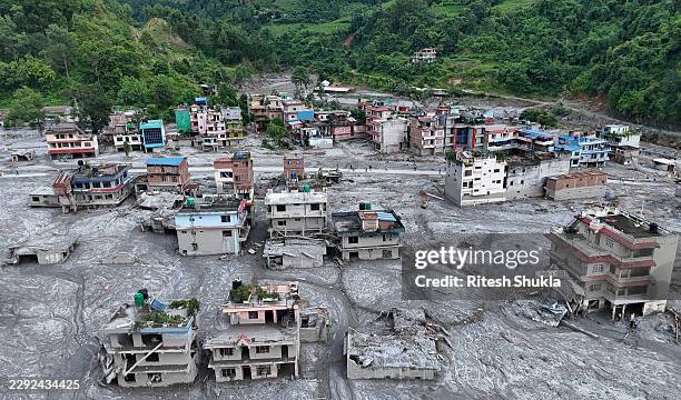 An Aerial view shows debris and mud covering settlements following flash floods on August 28, 2026 in DevGhat village, Nepal. Authorities said the...