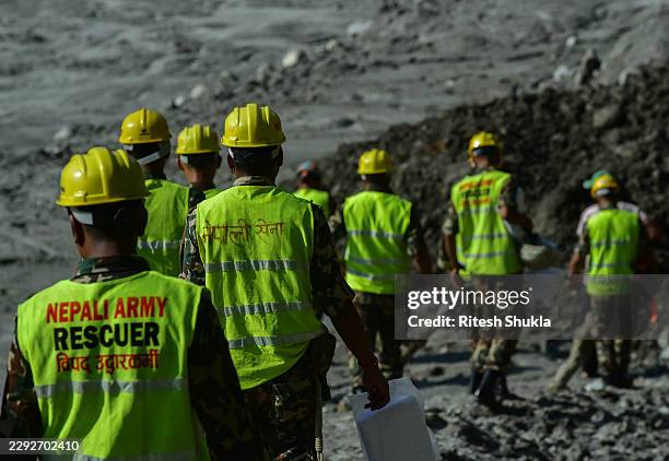 Nepal Army rescue team members walk through during rescue work near the swollen Trishuli River bed, close to Trishuli village, on August 30 in Nepal....